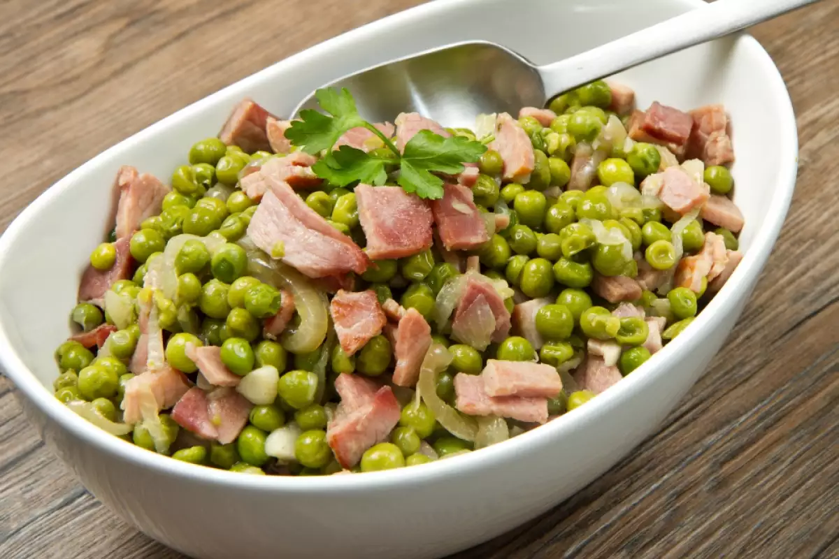 Speck, Erbsen und Zwiebeln – das ist alles, was Sie für die Zubereitung einer exklusiven Beilage benötigen, die allen ohne Ausnahme schmeckt.